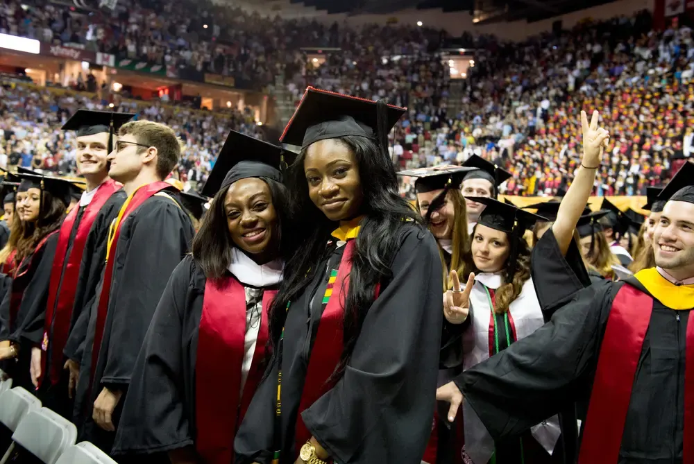 University of Maryland graduation — black cap and gown graduates in stadium